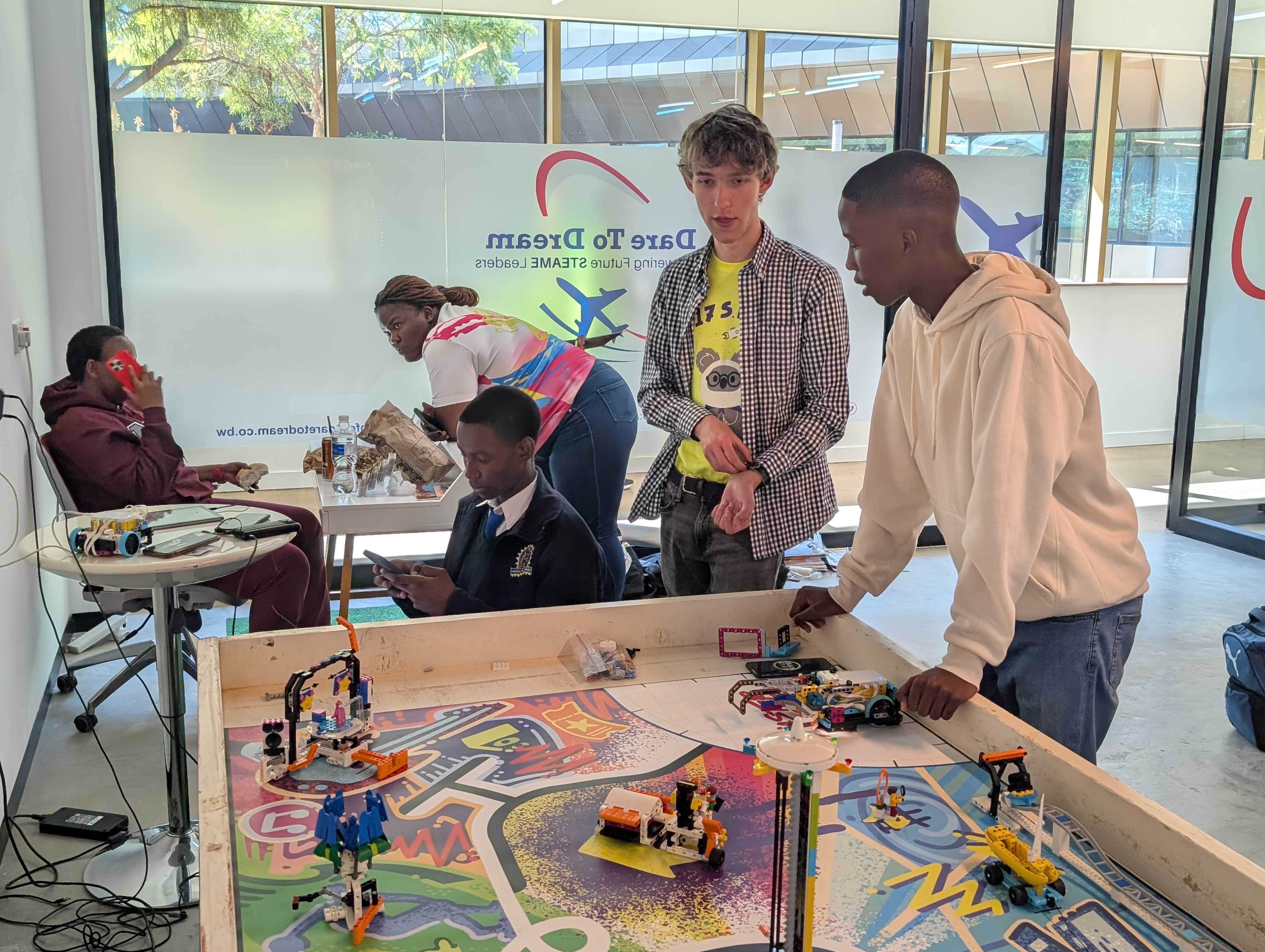 A few people around a MASTERPIECE field with a robot